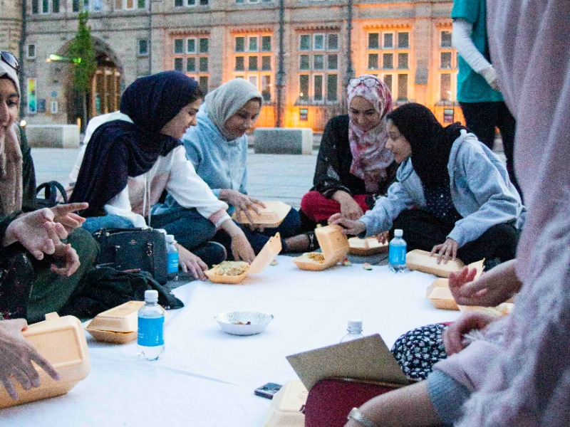 People sitting on ground enjoying their meal
