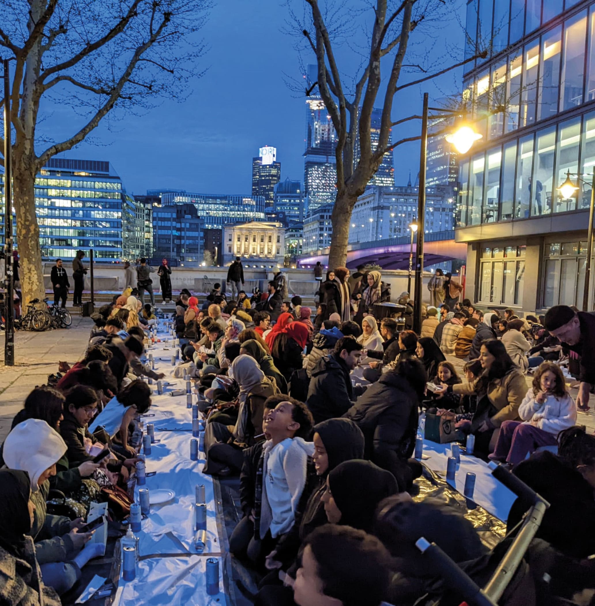 A lot of people sitting together on the ground for iftar