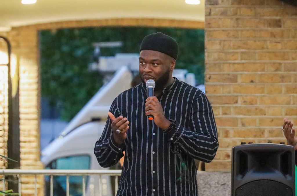 A man wearing black shirt holding the black speaker mike